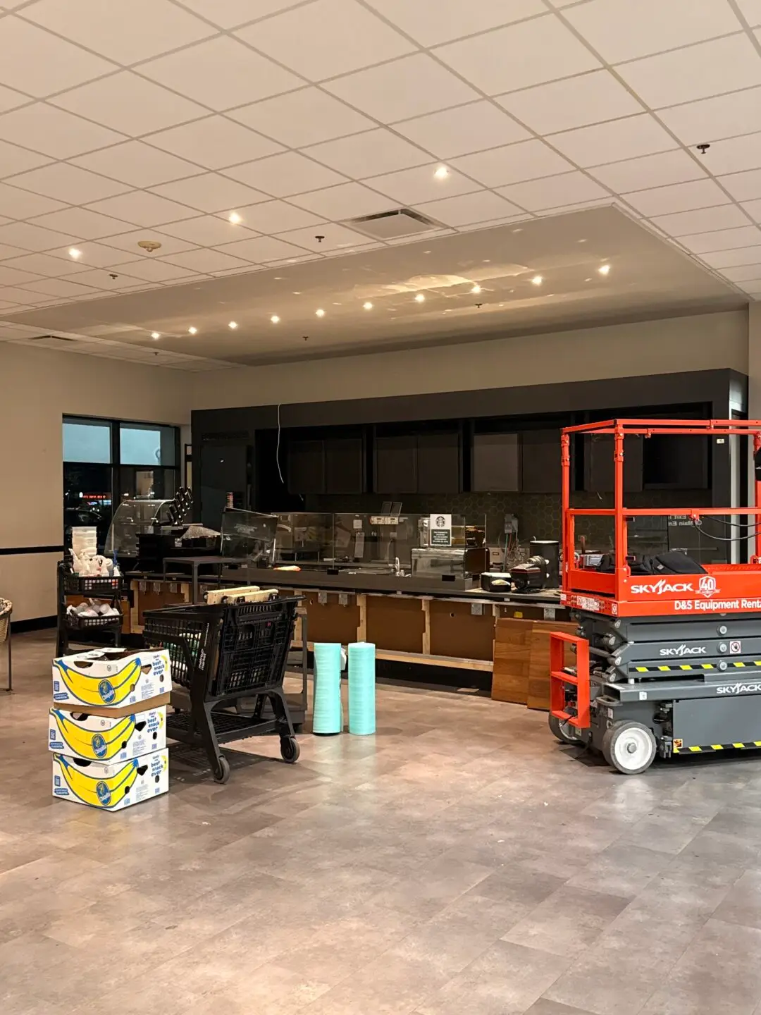 Commercial interior remodeling project in progress, with scaffolding and construction equipment in a cafe space.