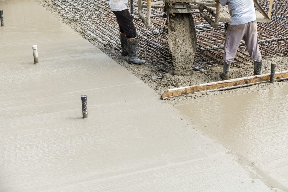 Construction workers pouring concrete for foundation work in Iowa.