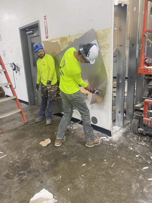 Commercial demolition crew working inside warehouse preparing for rebuild in Iowa.
