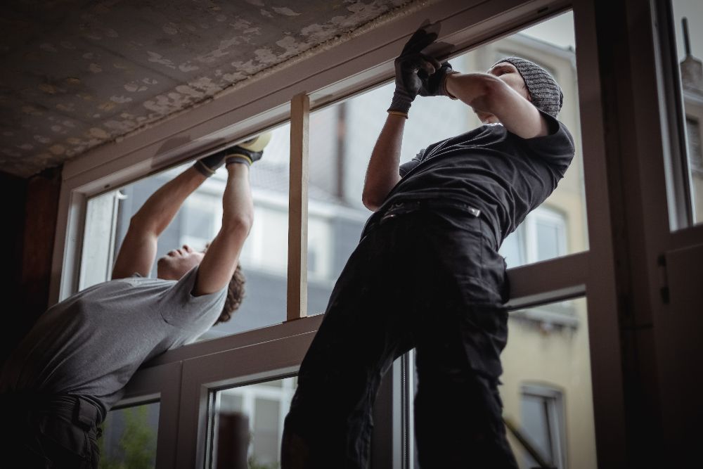 Installers securing a new window during a home window installation project